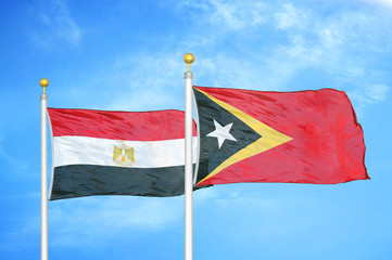Egypt and Timor-Leste East Timor two flags on flagpoles and blue cloudy sky