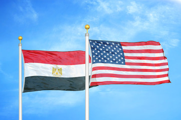 Egypt and United States two flags on flagpoles and blue cloudy sky
