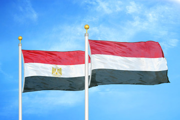 Egypt and Yemen two flags on flagpoles and blue cloudy sky