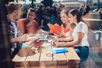 Students discussing project in outdoor cafe