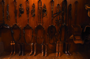 Bridles and riding boots in a stable