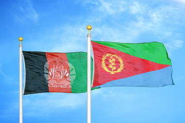 Afghanistan and Eritrea  two flags on flagpoles and blue cloudy sky