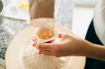 Obraz na płótnie Canvas A woman prepares the ingredients to make a sponge cake in her home kitchen