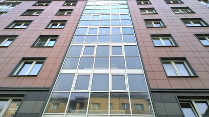 Glass and panel facade of a new multi-story  residential building. Sale and rental of economy class apartments and comfortable housing. Cityscape. City living. Real estate. Stay at home concept. 