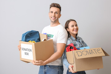 Volunteers with donations for orphans on grey background