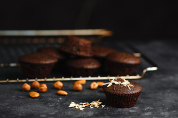 Chocolate cupcakes, muffins with banana and nuts, on a black table and a dark background. Top view, side view. Close-up and medium plan. Space for text.