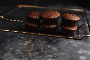 Chocolate cupcakes, muffins with banana and nuts, on a black table and a dark background. Top view, side view. Close-up and medium plan. Space for text.