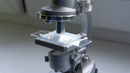 silver microscope in the sunlight from the window