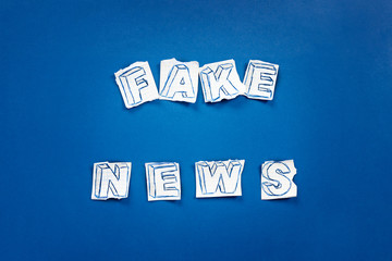 Paper art banner on blue backdrop in style zine wiht words fake news.