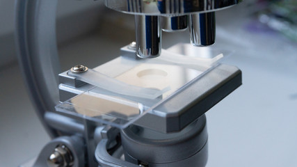 silver microscope in the sunlight from the window