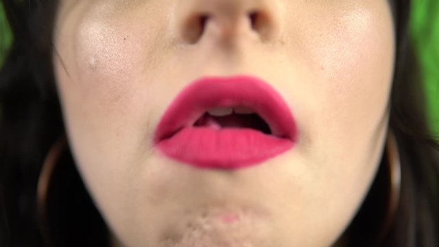 Young girl chewing blowing bubble gum, bright pink lips, close up green screen