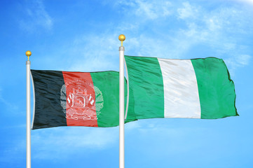 Afghanistan and Nigeria  two flags on flagpoles and blue cloudy sky