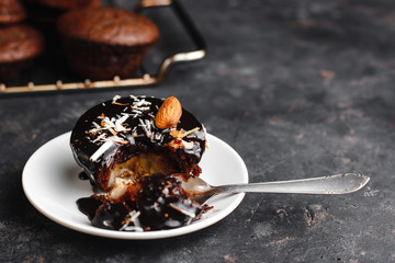 Chocolate cupcakes, muffins with banana, nuts and a Cup of coffee. On a black table and a dark background. Top view, side view. Close-up and medium plan. Space for text.