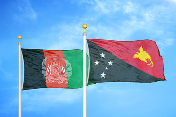 Afghanistan and Papua New Guinea  two flags on flagpoles and blue cloudy sky
