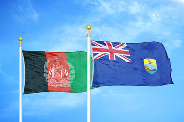 Afghanistan and Saint Helena  two flags on flagpoles and blue cloudy sky