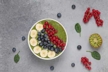 Healthy smoothie bowl with banana, blueberries, kiwi, spinach and red currant. The Breakfast delicious and the view from the top.