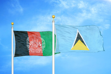 Afghanistan and Saint Lucia  two flags on flagpoles and blue cloudy sky
