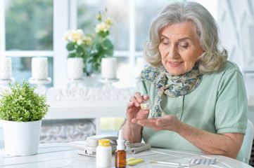 Close up portrait of sick senior woman sitting at table