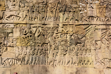 Fototapeta na wymiar Picturial stories carved into the wall at the Unesco World Heritage site of Ankor Thom, Siem Reap, Cambodia