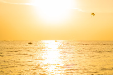 Tourists para-sailing in sunset time at Phuket Beach, Thailand