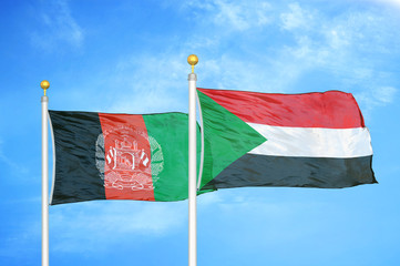 Afghanistan and Sudan  two flags on flagpoles and blue cloudy sky