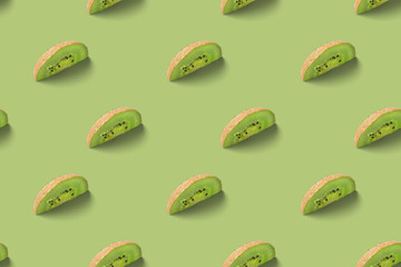 Kiwi slices pattern on a green background. Food texture. Kiwi seamless texture.