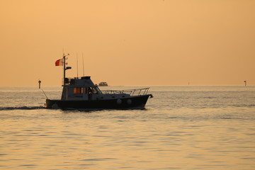 Obraz premium fishing boat at sunset