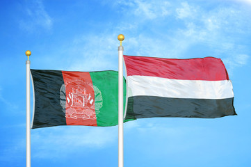 Afghanistan and Yemen  two flags on flagpoles and blue cloudy sky