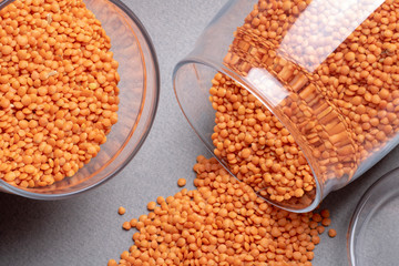 Red lentils and glass jars with red lentils, top view