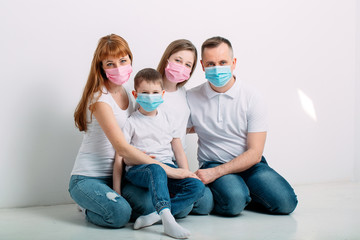 young family in medical masks during home quarantine.