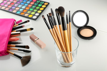 background with makeup brushes. make-up brushes in a glass