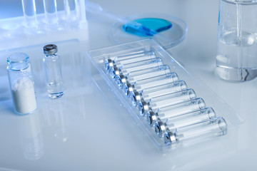 bottles with liquid medicine on a table in a laboratory. laboratory testing of antiviral drugs