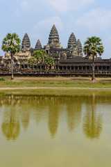 Fototapeta na wymiar Distinctive stupa towers on the roof of the UNESCO World Heritage Site of Angkor Wat are reflected in a man-made lake, Siem Reap, Cambodia