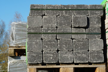 Concrete cubes or 
cobble stones stapled and attached pallettes in warehouse for building or  construction material
