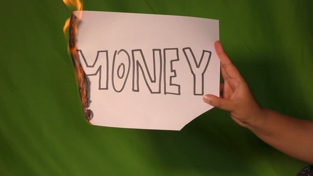 Money words burning on the paper and green screen