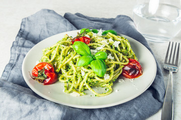Pasta spaghetti with homemade pesto sauce, roasted tomatoes and fresh basil leaves, vegetarian food