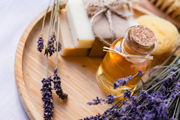 Concept of natural organic oil in cosmetology. Moisturizing skin care and aromatherapy. Gentle body treatment. Atmosphere of harmony relax. Wooden background, lavender flower, brush, soap. Close up