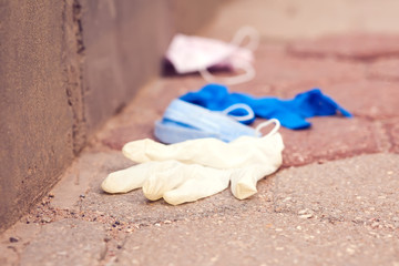 Used medical gloves and masks on ground. Environmental pollution concept