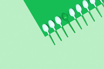 Picture of white plastic spoons on blue background. Flat lay, top view, copy space.