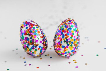 Fototapeta na wymiar Glitter easter eggs on white background