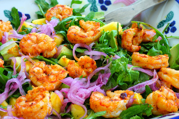 Fresh green salad with blackened shrimp, pickled red onions and pineapple in a bowl