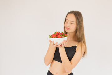 beautiful fitness girl with strawberries