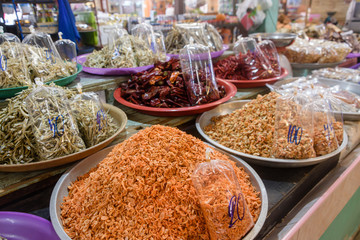 Bowls of cooked shrimp, prawns, anchovies and chilies for sale at a food market stall in Thailand