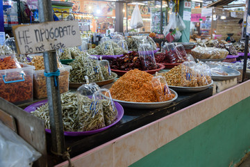 Bowls of cooked shrimp, prawns, anchovies and chilies, with a sign saying 