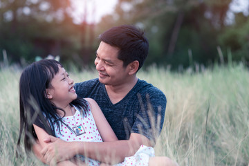 Father and daughter hugging in the green nature with love