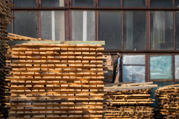 Warehouse for sawing boards on a sawmill outdoors. Timber mill, sawmill. Storage of planed wooden boards. Piles of wooden boards in the sawmill. Planking. Industry.