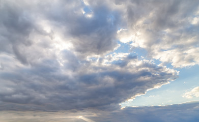 Fototapeta na wymiar Dramatic cloudy blue sky, sun behind the clouds.