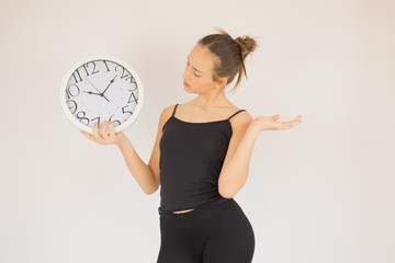 Young beautiful girl with big clock