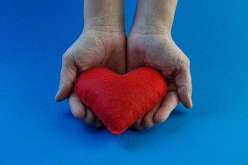 big red heart in hands on a blue background . medicine . Happy valentines day