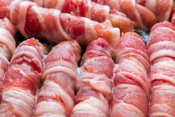 Sausages wrapped in bacon. bacon rolls close-up. Abstract bacon background.